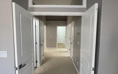 Dedicated entry hallway with double doors creating a private transition into the primary suite. Enhances privacy and overall flow of the home.