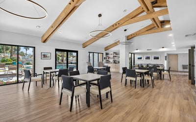 Expansive clubhouse interior with dining tables and lounge areas, ideal for hosting and connecting with neighbors.