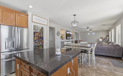Functional kitchen featuring granite countertops, stainless steel appliances, and center island with seating, perfect for meal prep and casual dining.