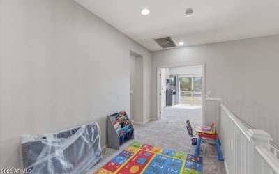 Open loft area overlooking the entryway, providing a flexible bonus space perfect for a playroom, second living room, study area, or media lounge in this Queen Creek home.