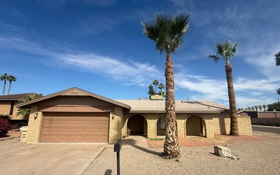 Beautiful exterior view of this Glendale property featuring mature palm trees, desert landscaping, and durable block construction. The home offers strong curb appeal with a welcoming front driveway and garage.