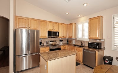 Kitchen with abundant cabinetry, granite surfaces, and stainless steel appliances. This Phoenix property offers both style and storage for modern living.