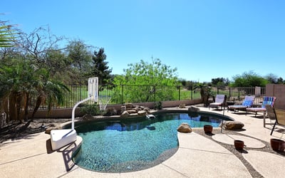 Backyard pool with unobstructed golf course views and desert landscaping. This Phoenix home offers privacy, open space, and resort-style outdoor features.