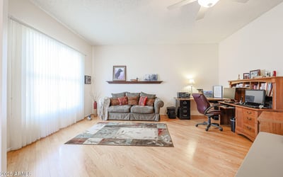 Spacious flex room perfect for a home office, hobby room, or additional living space with hardwood floors and bright windows.