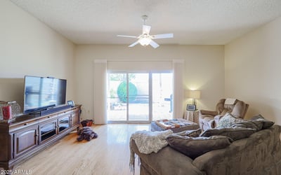 Light-filled living room with sliding doors to the backyard patio, hardwood floors, and open layout for comfortable living.