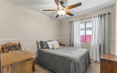 Cozy bedroom with carpet flooring, ceiling fan, and functional layout for everyday living.