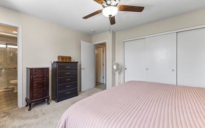 Bright primary suite with dual closets, ceiling fan, and convenient access to the bathroom. A functional and inviting layout.