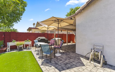 Inviting backyard with artificial turf, patio seating, and landscaped accents. Designed for entertaining and low-maintenance living.