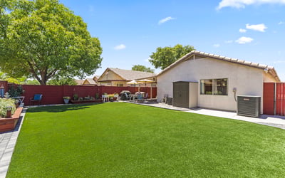 Large backyard with vibrant turf and landscaped borders, offering plenty of room for entertaining or recreation.