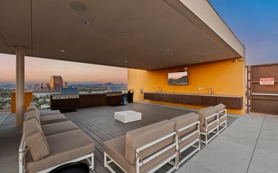 Stylish rooftop entertainment area featuring built-in grills, seating, and open-air design, ideal for hosting in Phoenix.