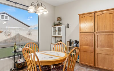 Cozy dining space with large window and backyard views, offering a bright and welcoming setting for meals in this Phoenix home.