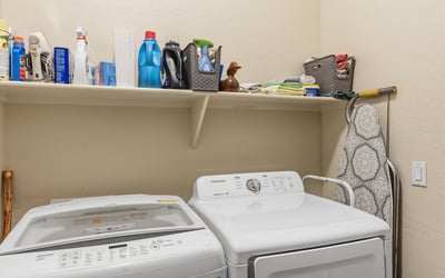Functional laundry room with washer, dryer, and storage shelving, adding everyday convenience to this Phoenix home.
