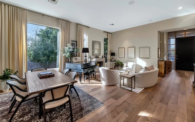 Flowing layout connecting dining and living spaces with modern finishes and warm wood flooring in this Phoenix property.