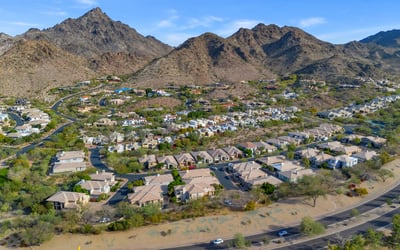 Aerial shot of homes near a manicured golf course with tree-lined streets and open green space in this Phoenix neighborhood.
