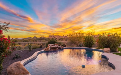Tranquil pool setting surrounded by Scottsdale desert landscaping, highlighted by dramatic sunset colors and peaceful outdoor living spaces.