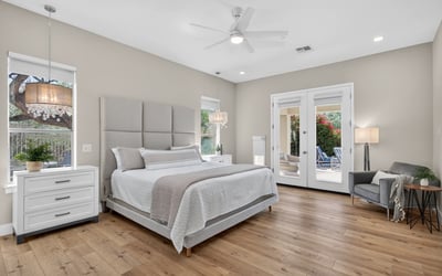 Beautiful Scottsdale primary suite with direct outdoor access, wood flooring, and modern ceiling fan, offering a peaceful and private retreat.