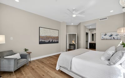 Open and airy Scottsdale bedroom featuring wood floors, large layout, and seamless flow into the ensuite bathroom.