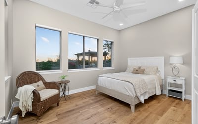 Scottsdale bedroom with multiple windows, wood flooring, and abundant natural light, creating an open and airy feel.