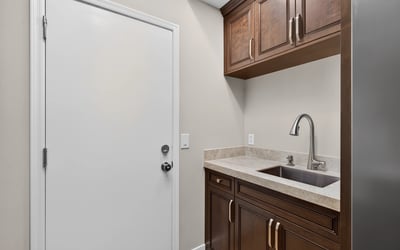 Efficient Scottsdale laundry room with built-in cabinetry, sink, and counter space for added convenience and organization.