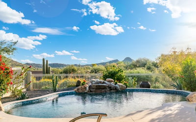 Scottsdale backyard pool overlooking scenic desert and mountain views, enhanced by mature landscaping and peaceful surroundings.