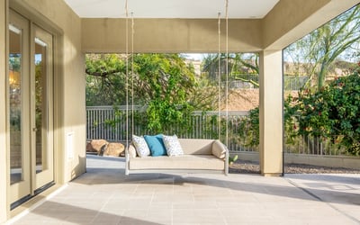 Scottsdale outdoor living space with hanging swing bench, tiled patio, and serene backyard views.
