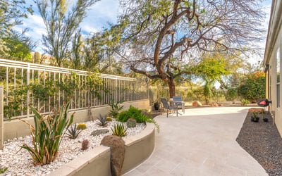 Scottsdale side yard with low-maintenance desert landscaping, stone accents, and paved walkway for easy upkeep.