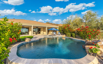 Scottsdale outdoor space featuring pool, spa, and lush landscaping, creating a resort-style backyard retreat.