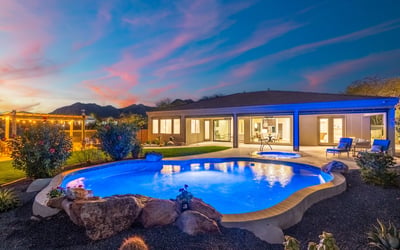 Scottsdale outdoor space with pool, spa, and landscaped yard, creating a serene and inviting nighttime retreat.