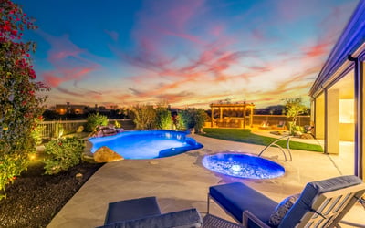 Scottsdale backyard with pool, pergola kitchen, fire pit, and sunset views, designed for upscale outdoor gatherings.