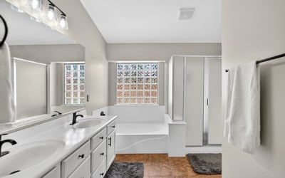 Bright primary bathroom with dual vanities, soaking tub, and walk-in shower. Functional layout offers everyday comfort in this Casa Grande property.