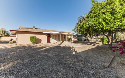 Expansive backyard with gravel landscaping and mature trees. This Sun City home provides a private outdoor retreat with minimal upkeep.