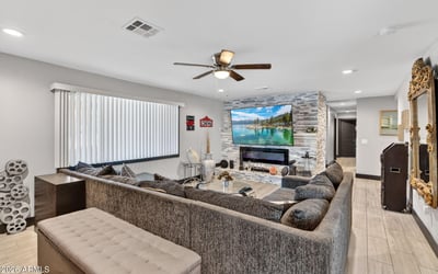 Updated living space with sleek fireplace, neutral palette, and modern finishes, offering comfort and style in this Phoenix home.