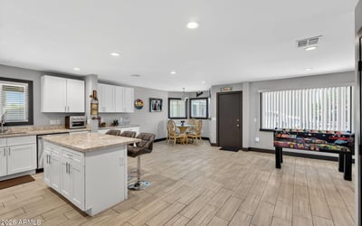 Expansive open-concept space with updated kitchen, modern flooring, and ample room for gathering, perfect for today s Phoenix lifestyle.