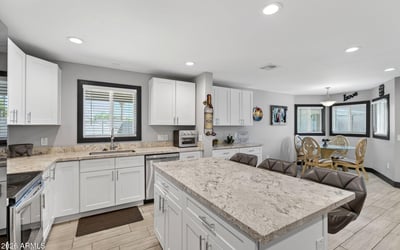 Open kitchen flowing into dining area with updated cabinetry, modern finishes, and natural light enhancing the space.