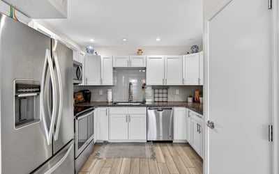 Contemporary kitchen in Scottsdale with stainless appliances, white cabinets, and tile backsplash offering both style and functionality.