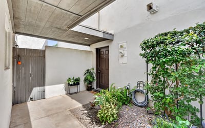 Private Scottsdale covered entry with desert landscaping and shaded design, creating a welcoming and low-maintenance entrance to the home.