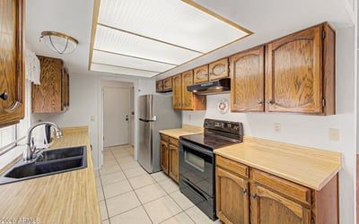 Enjoy a functional kitchen with extensive storage, ample countertops, and natural light from the window above the sink. The efficient design supports comfortable daily living while maintaining a warm, welcoming feel.