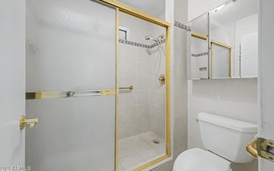 This bathroom features a spacious walk-in shower with glass enclosure, tile finishes, and convenient accessibility enhancements. The clean design offers both practicality and long-term usability.