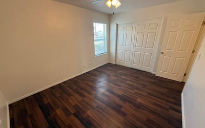 Spacious bedroom featuring a large closet, neutral finishes, and durable flooring. The room's generous proportions create a comfortable setting for a variety of furniture configurations.