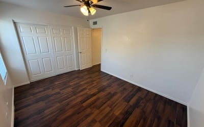 Well-appointed bedroom with ceiling fan, ample closet storage, and attractive flooring throughout. This comfortable space offers privacy and flexibility for residents seeking functional living areas.
