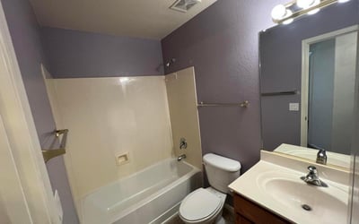 Full bathroom featuring a tub and shower combination, vanity storage, and easy-care finishes. Designed to comfortably accommodate guests and everyday household use.