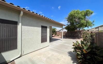 Large patio area overlooking the landscaped backyard with mature trees and low-maintenance grounds. This outdoor living space offers the perfect setting for dining, entertaining, and enjoying the Arizona lifestyle in a desirable Goodyear location.