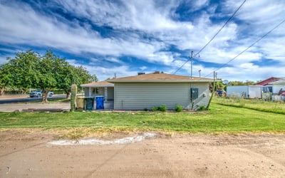 The expansive rear yard offers open lawn areas, mature trees, and abundant outdoor space for entertaining, recreation, gardening, or future customization, complementing this updated Buckeye property.