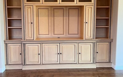 Beautiful custom entertainment wall featuring rich built-in cabinetry, open display shelves, enclosed storage, and premium craftsmanship that adds elegance and functionality to the great room.