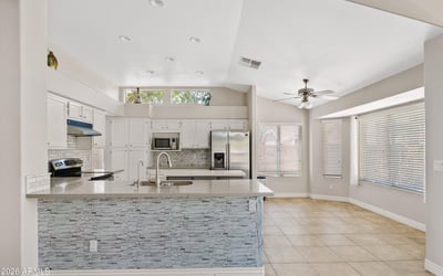 This bright kitchen offers updated cabinetry, newer countertops, stainless steel appliances, a large center island, and a sunny breakfast area. The open design provides an ideal setting for cooking, casual dining, and entertaining while enjoying seamless flow to the surrounding living spaces.