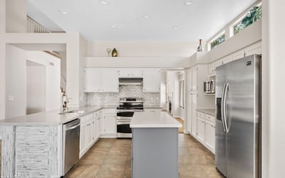 This updated kitchen showcases newer cabinetry, modern countertops, stainless steel appliances, recessed lighting, and a spacious center island. The open layout makes meal preparation and entertaining effortless in this Chandler home.