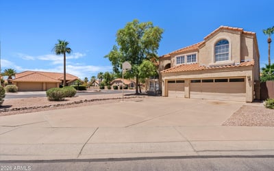 A broad front view highlights the home's attractive architecture, mature landscaping, and expansive driveway. This move-in-ready Chandler home combines timeless style with everyday convenience.