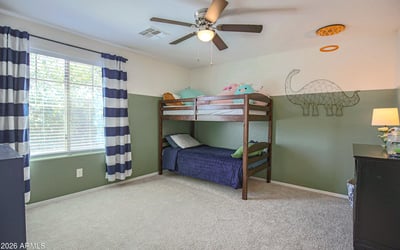 Large bedroom with plush carpeting, ceiling fan, and oversized window creating a bright, cheerful space. Perfect for children, guests, or a flexible bonus bedroom.