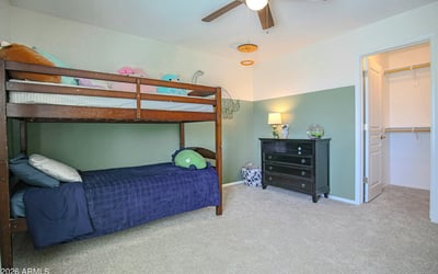 Well-appointed secondary bedroom featuring a walk-in closet, plush carpeting, and generous space for furniture. A versatile room designed for everyday comfort and organization.