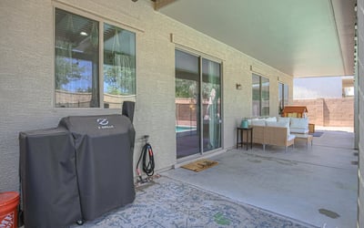 Large covered patio offering comfortable seating, shade, and seamless access to the backyard pool area. Perfect for outdoor gatherings and everyday living in this Waddell home.